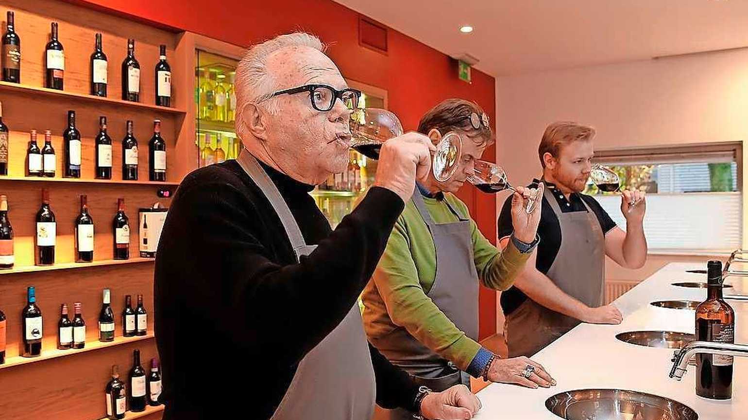 Three people tasting wine inside a lab tasting room